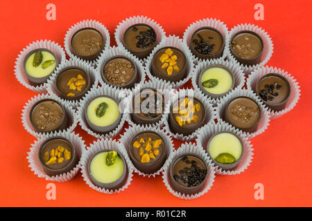 Bonbons de chocolat avec divers matériaux dans une enveloppe de papier sur un arrière-plan lumineux. Banque D'Images