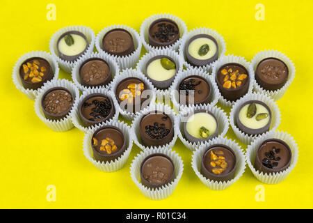 Bonbons de chocolat avec divers matériaux dans une enveloppe de papier sur un arrière-plan lumineux. Banque D'Images