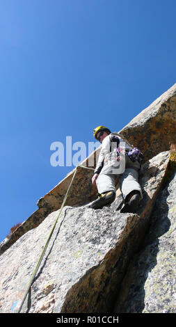 Guide de montagne alpiniste sur une route de granit raide dans les Alpes de Suisse sur une belle journée Banque D'Images