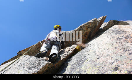 Guide de montagne alpiniste sur une route de granit raide dans les Alpes de Suisse sur une belle journée Banque D'Images