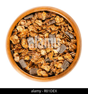 Crunchy granola au chocolat dans un bol en bois. Les céréales croustillantes, faites de grains entiers grillé roulées et flocons d'avoine, jus et chocolat noir date de morceaux. Banque D'Images