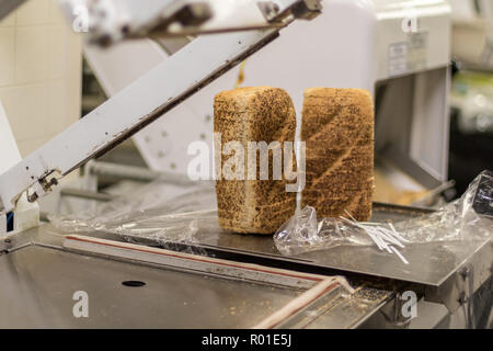 Pain frais emballé sur une machine dans une boulangerie locale. Banque D'Images