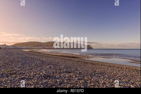 Une vue de courbée du Llandudno bordé par des rives hôtels rieuses au crépuscule. Le grand orme pointe est dans la distance et d'une décoloration blue sky est ab Banque D'Images