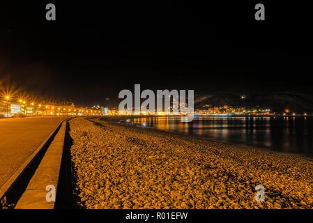 Une vue de courbée du Llandudno bordé par des rives hôtels rieuses dans la nuit. Le grand orme pointe est tout juste visible dans la distance et la nuit s Banque D'Images