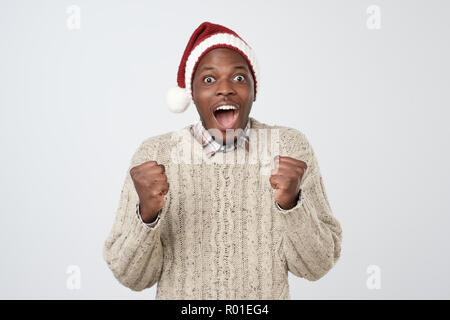 Noël drôle homme africain dans Red Hat sur fond gris Banque D'Images