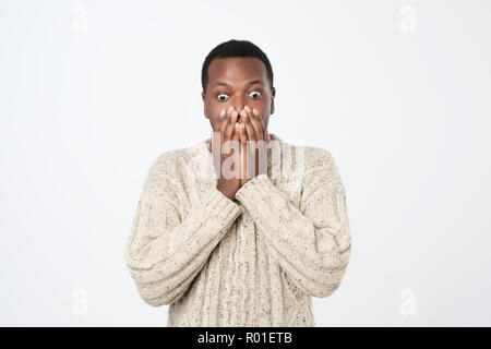 Choqué homme africain couvrant sa bouche avec les mains Banque D'Images