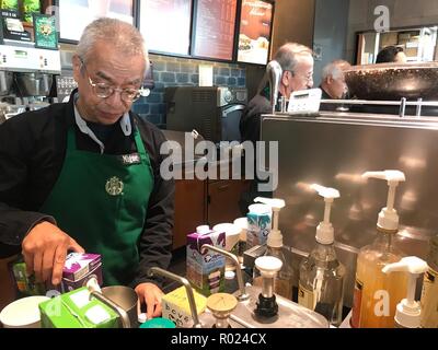 30 octobre 2018, le Mexique, l'Mexiko-Stadt : Miguel Angel Martinez Sarmiento fonctionne comme un barista dans une branche de l'US café chambre 'Starbucks' et verse le lait en boîte. Tous les employés de la cafétéria, qui a ouvert ses portes à Del Valle sur au début de septembre, ont plus de 60 ans. (Dpa 'US coffee house est un cadre supérieur de la direction générale dans la ville de Mexico" à partir du 01.11.2018) Photo : Antonia Märzhäuser/dpa Banque D'Images