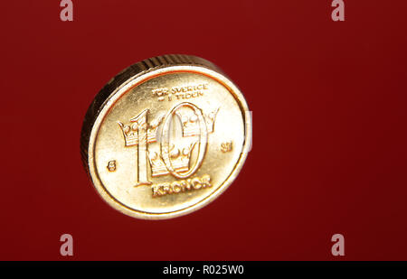 10 pièce d'or couronne suédoise sur fond rouge. Banque D'Images