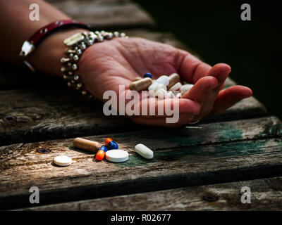 Une femme avec un grand nombre de pilules dans sa main, de différentes tailles et couleurs Banque D'Images