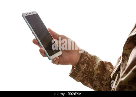 US Army. Jeune soldat holding a mobile phone debout sur fond blanc Banque D'Images