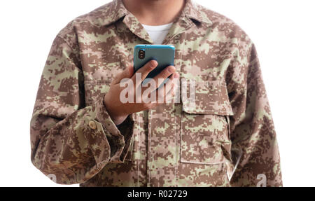 US Army. Jeune soldat holding a mobile phone debout sur fond blanc Banque D'Images