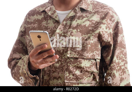 US Army. Jeune soldat holding a mobile phone debout sur fond blanc Banque D'Images