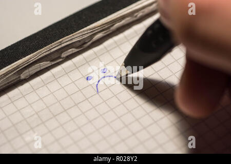 La main de l'encombrement smiley sur le bloc-notes Banque D'Images