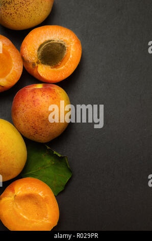 De délicieux abricots mûrs sur schiste noir arrière-plan. Banque D'Images
