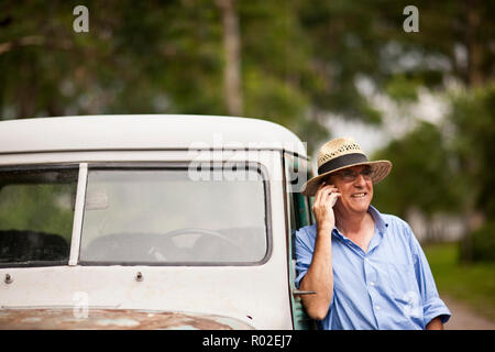 Man talking on cell phone tout en se penchant sur le camion. Banque D'Images