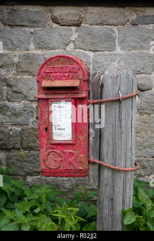 Ancienne boite aux lettres attaché à un poteau dans la campagne, Nidderdale, Yorkshire du Nord. Banque D'Images