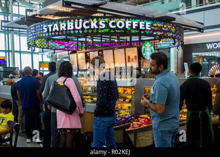 2 mai 2018 d'un père qui garde ses yeux sur son fils alors que la queue pour un café Starbucks dans le Terminal 5 à l'Aéroport International d'Heathrow à Londres airport Banque D'Images