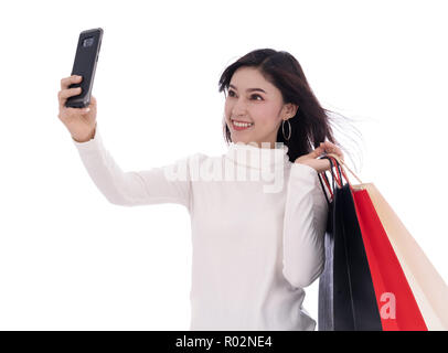 Shopping woman using smartphone pour prendre un isolé selfies sur fond blanc Banque D'Images