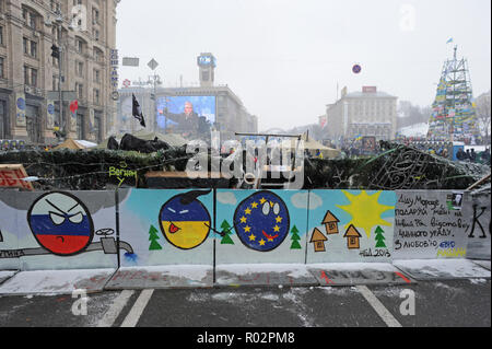7 décembre 2013 - Kiev, Ukraine : une barricade de la place de l'Indépendance de Kiev avec dessins représentant l'Ukraine de rejoindre l'Europe au détriment de la Russie et de son gaz de la diplomatie (représenté par un pipeline sur le dessin). Des milliers de manifestants ukrainiens se sont réunis à la place de l'indépendance, rebaptisée "EuroMaidan', pour protester contre leur rejet par le gouvernement d'un accord commercial historique avec l'Union européenne (UE). Barricade de l'ONU avec des émoticônes représentant la Russie, l'Ukraine, et l'Union europŽenne prés de la place de l'Independance a Kiev, ou des dizaines de milliers de personnes manifestent contre la déc Banque D'Images
