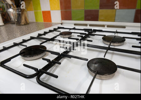 Qui, à première vue, une cuisinière à gaz révèle la saleté, huile, graisse, éclaboussé de cires grasses, les bactéries qui brillent sous la lumière UV montrant les pratiques d'hygiène Banque D'Images