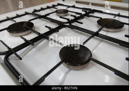 Qui, à première vue, une cuisinière à gaz révèle la saleté, huile, graisse, éclaboussé de cires grasses, les bactéries qui brillent sous la lumière UV montrant les pratiques d'hygiène Banque D'Images