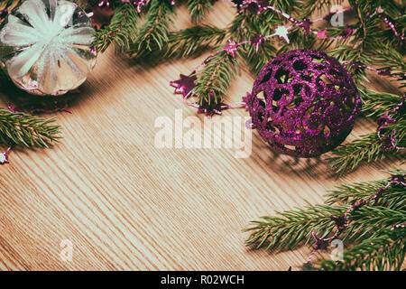 Noël et Nouvel An en arrière-plan de fête style rétro. Branches d'épinette avec perles en forme d'étoiles et de boules de Noël sur la surface en bois. Copy space Banque D'Images