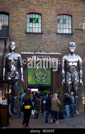 Londres, ANGLETERRE - 12 octobre, 2018 Deux grands robots à l'entrée d'un magasin appelé Cyberdog dans Camden Lock Market ou Camden Town avec les gens autour de moi Banque D'Images