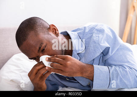 Close-up d'un jeune homme africain soufflant son nez Banque D'Images