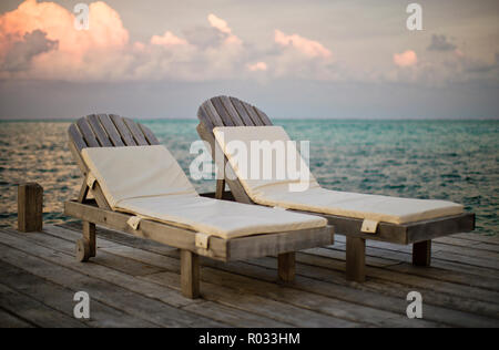 Deux chaises vides côte à côte sur un quai en bois. Banque D'Images