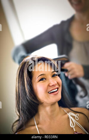 Young woman getting her hair blow-séchées Banque D'Images