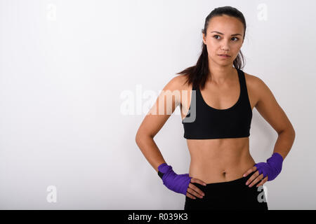 Studio shot of young Asian woman fighter penser tout en se posant w Banque D'Images