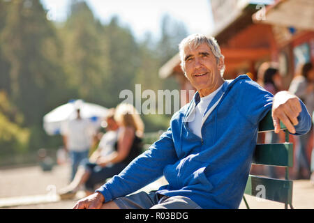Portrait of a happy senior man sitting on a park bench. Banque D'Images