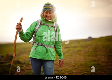 Confiant mature woman en randonnée dans la campagne environnante.