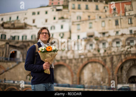 Homme d'âge moyen nerveux en attente avec un bouquet de fleurs. Banque D'Images