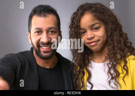 Affichage de l'appareil photo d'un père noir et sa jeune fille de sourire et de prendre des selfies Banque D'Images