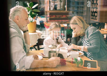 Heureux grands-parents de profiter de leur temps en famille avec mignon smart girl Banque D'Images