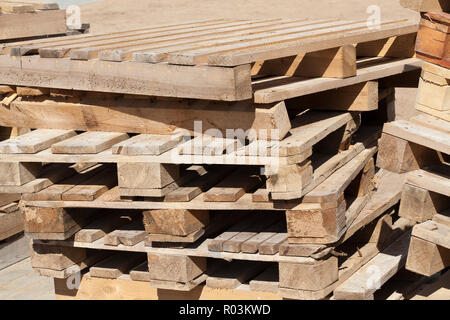 Palettes en bois vides de vieux carreaux, mensonge on construction site Banque D'Images