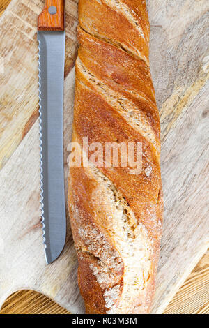 L'un de couleur claire fraîche avec un délicieux pain croquante, close-up dans la cuisine avec un couteau Banque D'Images