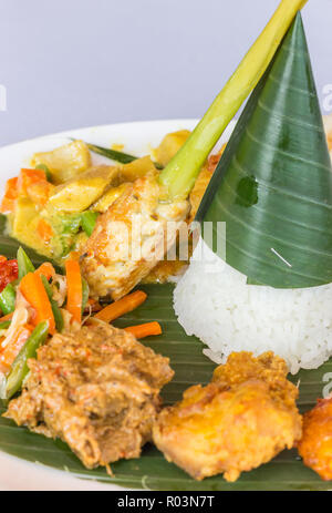 Nasi Campur Bali avec le tempeh, poulet et légumes, servis sur une feuille de bananier Banque D'Images