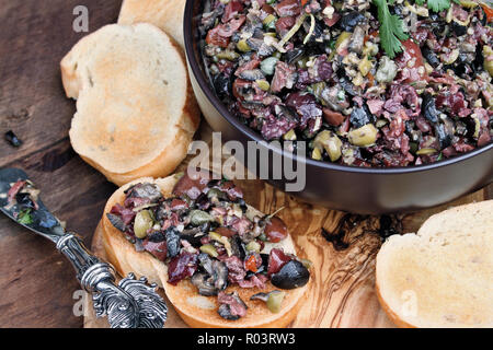 Tapenade d'Olives mixtes maison faite avec de l'ail, les câpres, l'huile d'olive, Kalamata, olives vertes et noires réparties sur du pain grillé. Tourné à partir de l'image ci-dessus. Banque D'Images