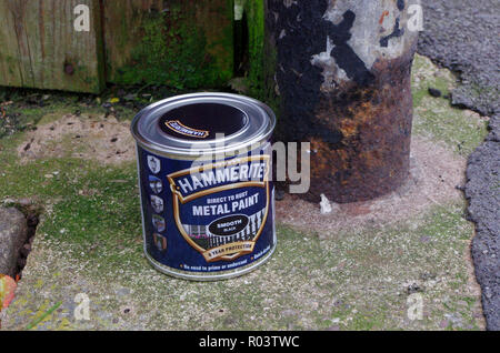 Boîte de Peinture métal Hammerite Noir lisse à côté d'une barrière en métal rouillé, UK Banque D'Images