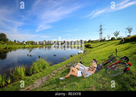 Essen, Ruhr, Allemagne, projet de développement urbain Niederfeldsee, jeune couple se trouve dans la prairie Banque D'Images