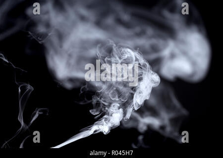 Photo de l'élaboration de fumée d'une cigarette sur un fond noir Banque D'Images