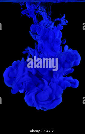 Peinture acrylique bleu nuage dans l'eau isolé sur fond noir. Banque D'Images