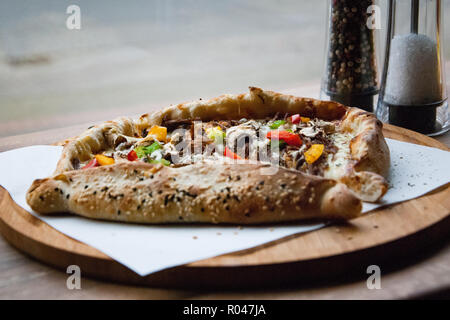Pizza végétarienne sur une plaque de bois Banque D'Images