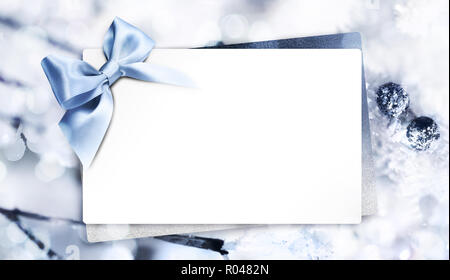Cadeau ou carte de souhaits avec blue ribbon bow floue sur fond de noël bleu, blanc copy space Banque D'Images
