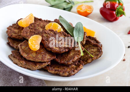 Escalopes de foie délicieux avec la mandarine sur une plaque blanche sur la table. Banque D'Images