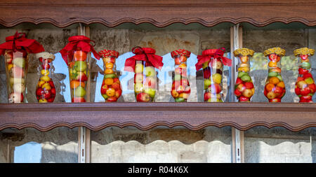 Les bocaux en verre avec couvercles décoratifs colorés remplis de divers fruits Banque D'Images