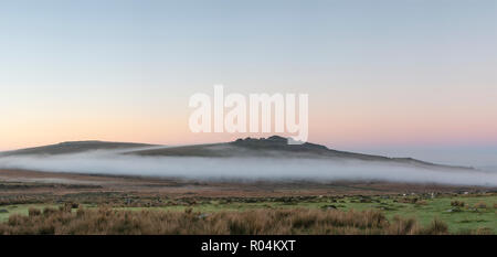 Superbe paysage de brouillard lever du soleil sur les TDR dans le Dartmoor pics révélant à travers la brume Banque D'Images