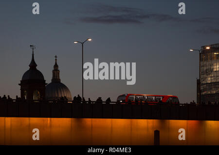 Les banlieusards de l'heure de pointe du soir et un cross London bus London Bridge (avec le dôme de la Cathédrale St Paul) après le début de l'hiver, le 29 octobre 2018, à Londres, en Angleterre. Banque D'Images